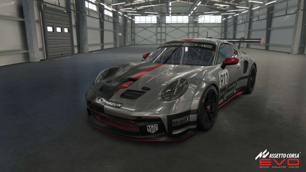 Porsche Cup d'Assetto Corsa Evo dans un hangar, montrant des détails réalistes du modÚle et de l'environnement.